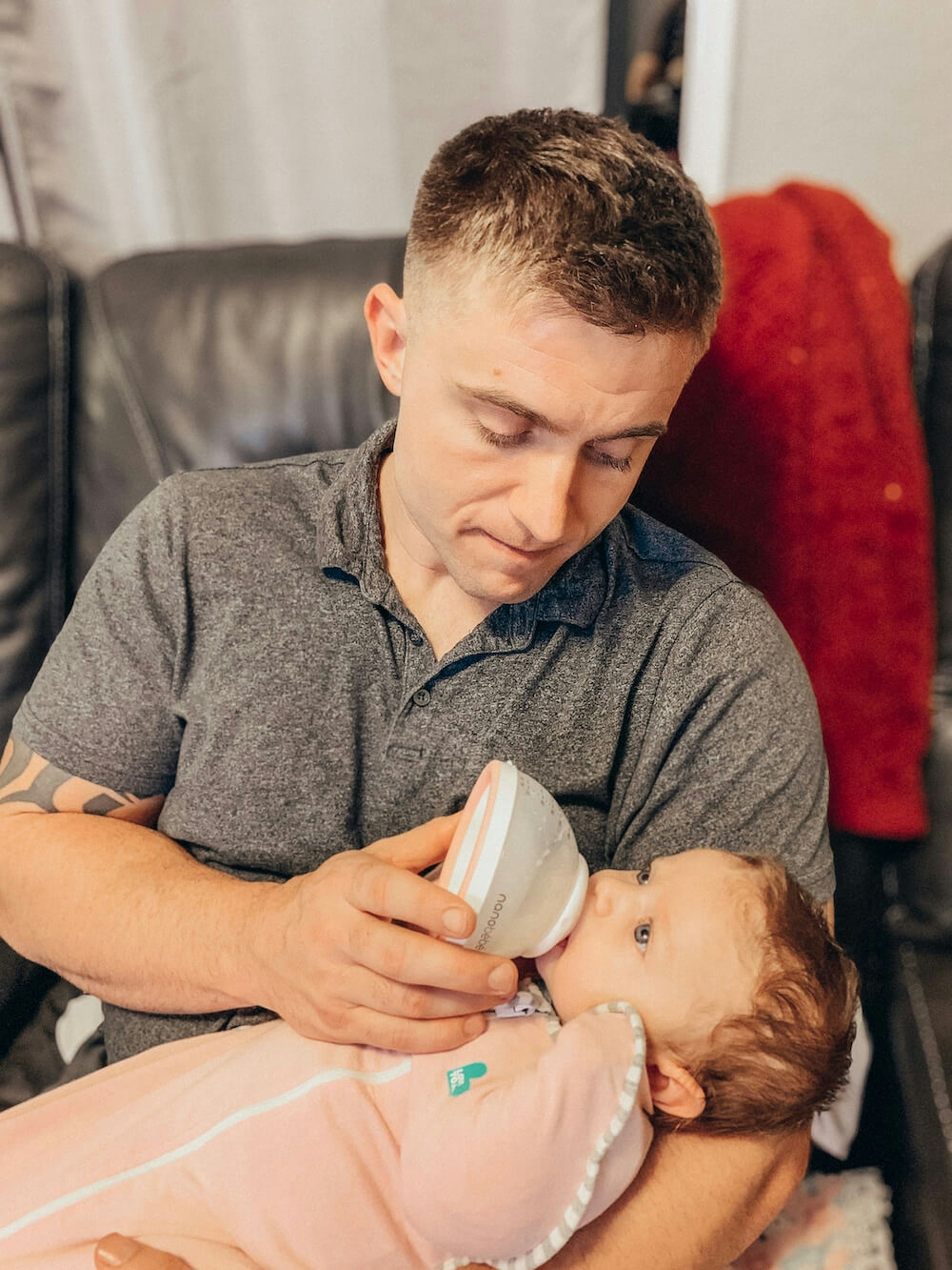 Dad feeding baby with breastmilk bottle
