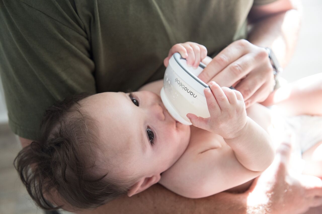 baby drinking from breastmilk bottle