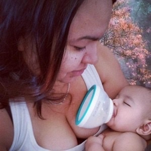 breastmilk bottle being fed to baby