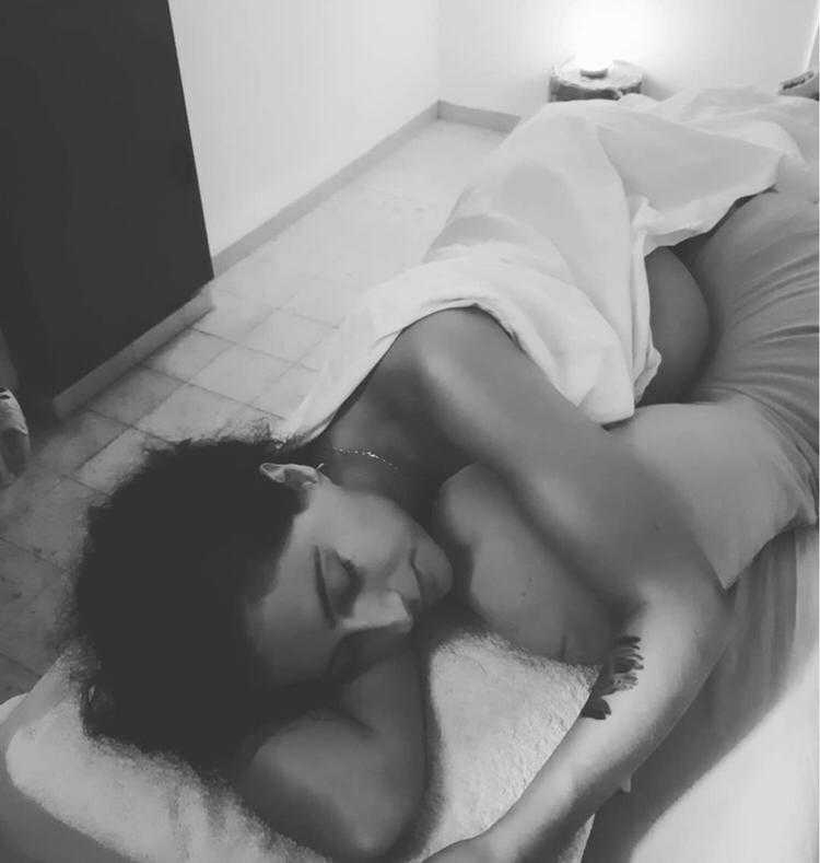 nicole laying pregnant for massage in black and white